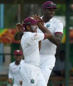 Devendra Bishoo celebrates a wicket with skipper Jason Holder during his last Test against Sri Lanka in October 2015