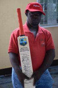 A student poses with a bat they received from the West Indies ODI team in 2011