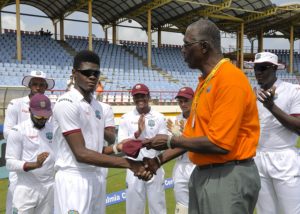 Alzarri Joseph on debut receives his cap from West Indies manager Joel Garner before the start of the 3rd Test between West Indies and India. He quickly made an impact with two huge wickets.