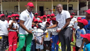 Christopher Barnwell (left) presents the bat and gloves to DCC president Alfred Mentore