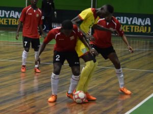 Guyana's lone goalscorer Douquan Wilson being aggressively defended by two Surinamese.