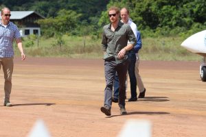 Prince Harry walks across a section of the 4300ft Surama Airstrip to be greeted by villagers